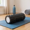 Rullo in schiuma per massaggio su tappetino da yoga
